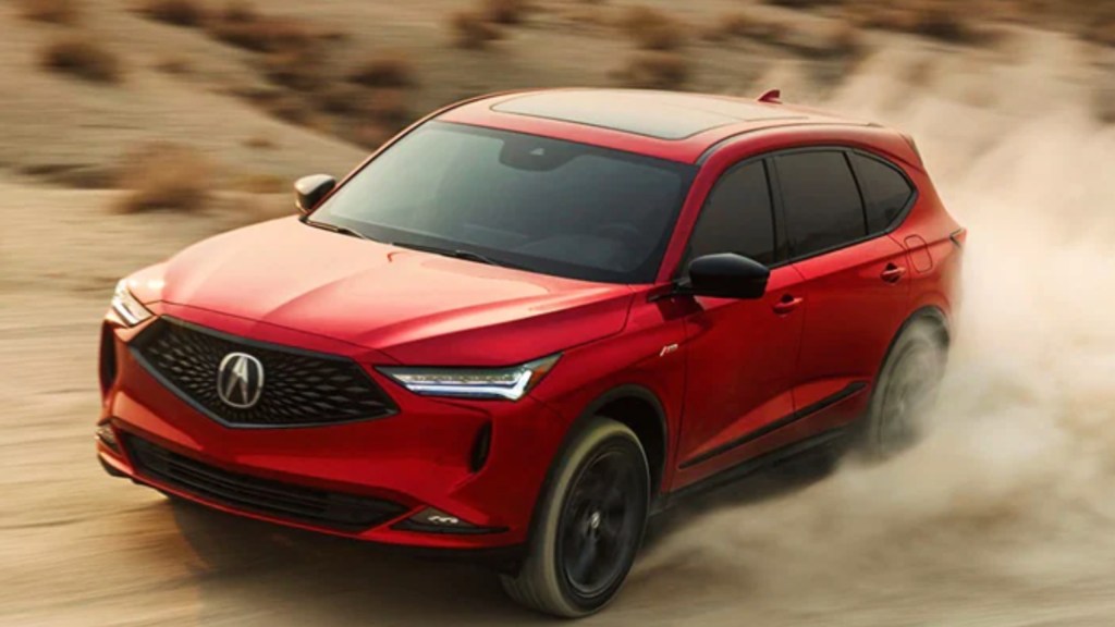 A red 2022 Acura MDX midsize SUV is driving off-road.