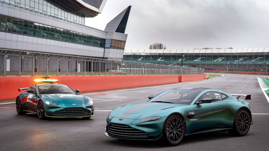 A green 2022 Aston Martin Vantage F1 Edition to the right of the green Vantage F1 safety car on a racetrack