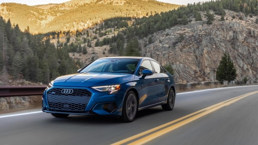 A blue 2022 Audi A3 sedan is driving on the road.