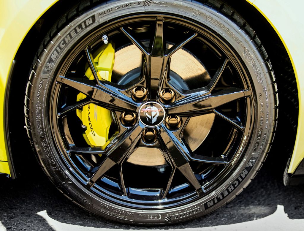 A close-up view of the yellow brake calipers and black wheels of a yellow 2022 Chevrolet Corvette IMSA GTLM Championship Edition