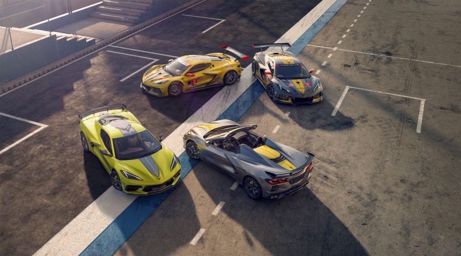 An overhead view of a yellow 2022 Chevrolet Corvette IMSA GTLM Championship Edition Coupe and gray Convertible in front of the yellow No. 3 and gray No.4 Corvette C8.R race cars on a racetrack