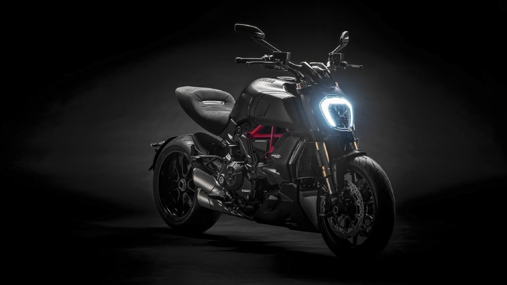 A black-and-red 2022 Ducati Diavel 1260 S with its LED headlight on