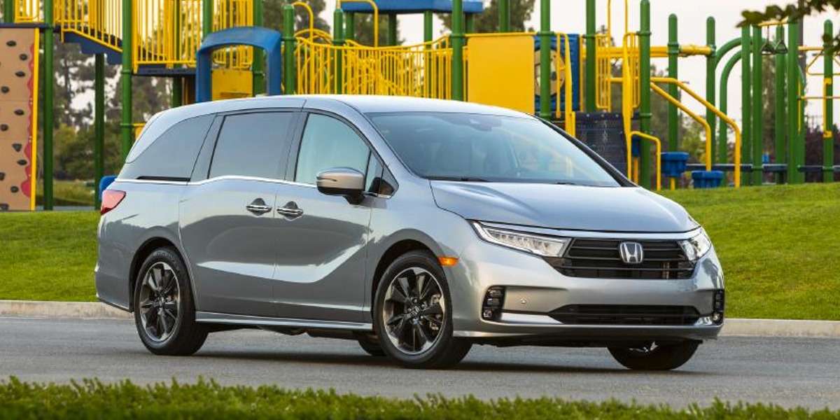 A gray 2022 Honda Odyssey minivan is parked near a jungle gym.