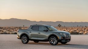 A gray-green 2022 Hyundai Santa Cruz parked on a paved road in the desert