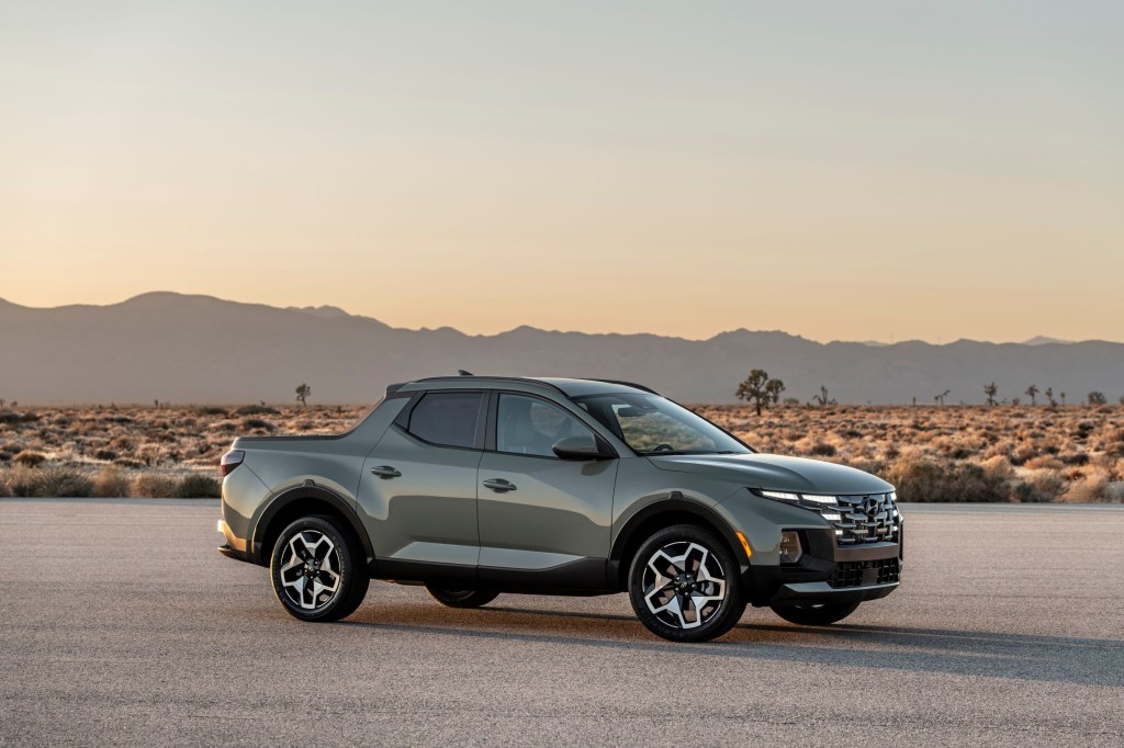 A gray-green 2022 Hyundai Santa Cruz parked on a paved road in the desert