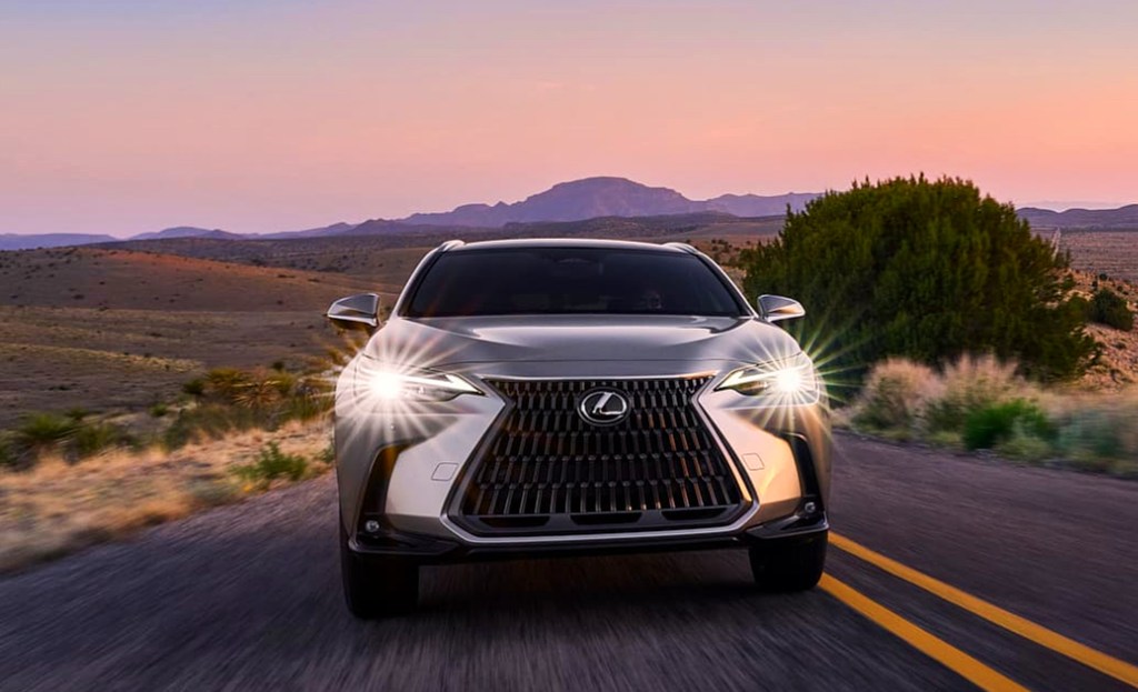 A gray 2022 Lexus NX subcompact luxury SUV is driving on the road. 