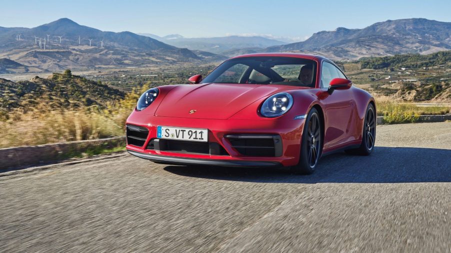 A red 2022 Porsche 911 Carrera GTS Coupe drives around a mountain road