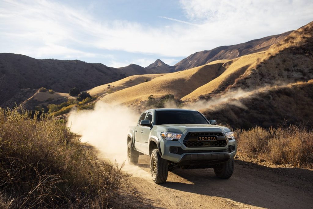 a 2022 Toyota Tacoma Trail Edition on a dusty mountain trail kicking up dirt