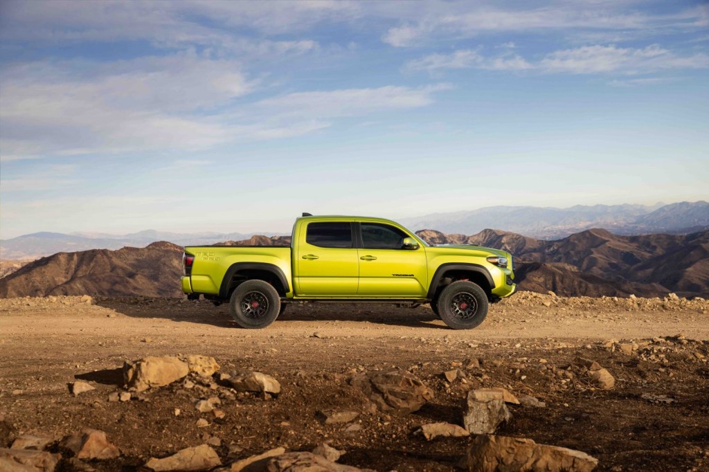 side view of an electric green Toyota Tacoma TRD Pro 2022 model driving on a sandy trail