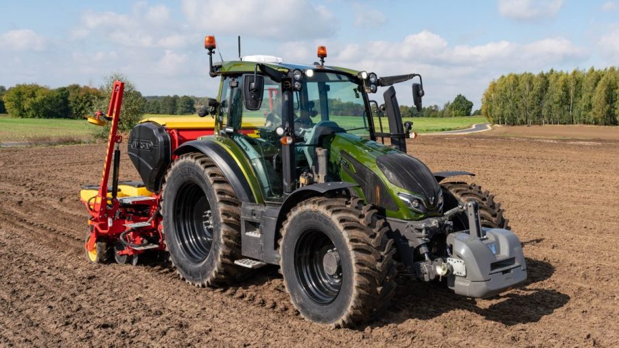 Valtra G 135 Versu utility tractor model in a crop field on a sunny day