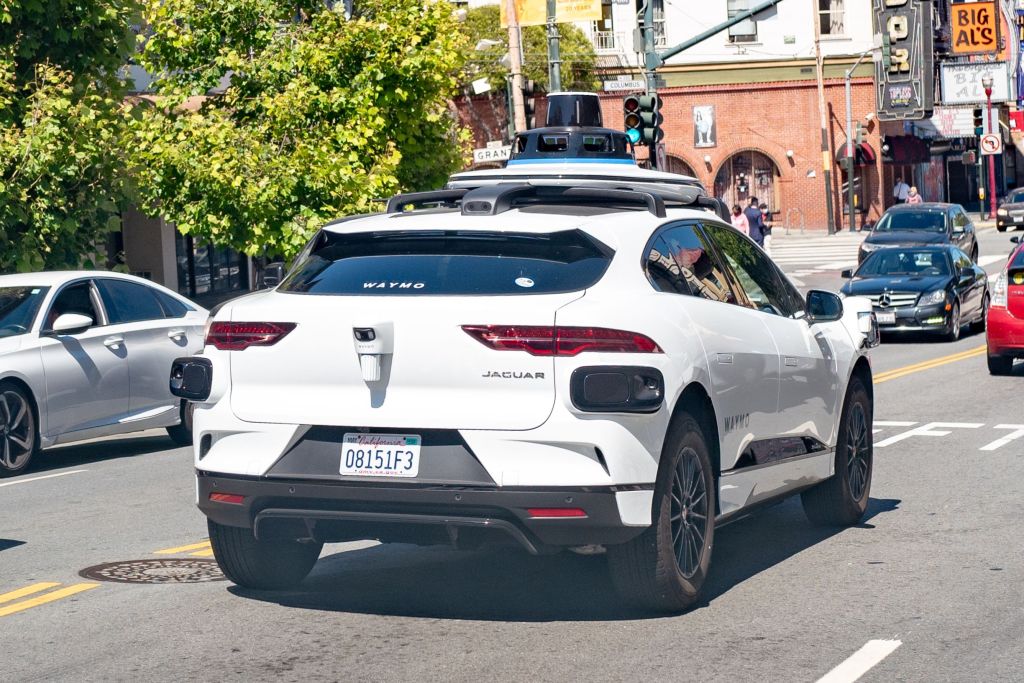 A white Waymo semi-autonomous Jaguar I-Pace car testing on the streets of San Francisco