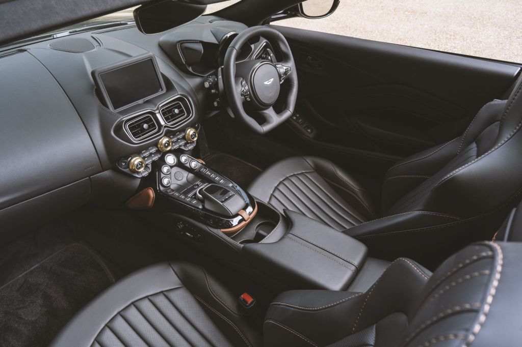 The black-and-brown leather seats and bronze-highlighted black dashboard of the A3-inspired Q by Aston Martin Vantage Roadster
