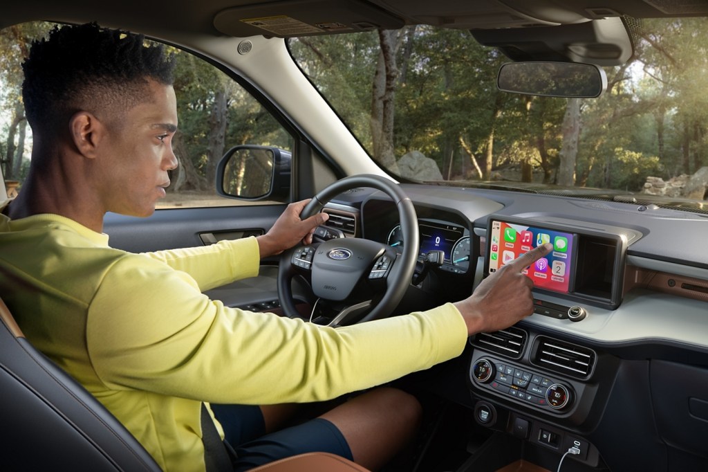 a driver uses the infotainment system of the 2022 Ford Maverick compact pickup truck