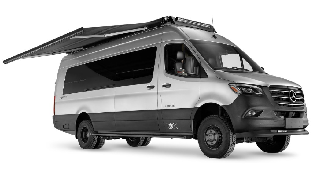 A silver-and-black Airstream Interstate 24X with its awning extended