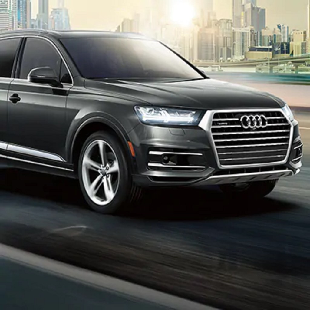 A black 2021 Audi Q7 racing down a highway.