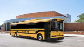 A yellow BYD electric school bus driving down a street.