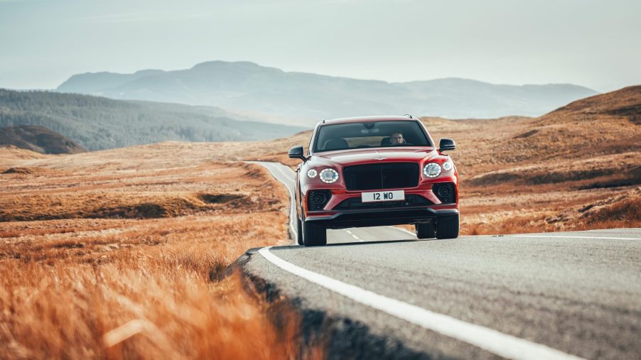 A red Bentley Bentayga S on a twisty back road