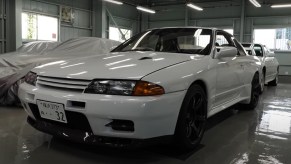 A white Built by Legends Nissan R32 Skyline GT-R restomod in the BBL surrounded by other cars