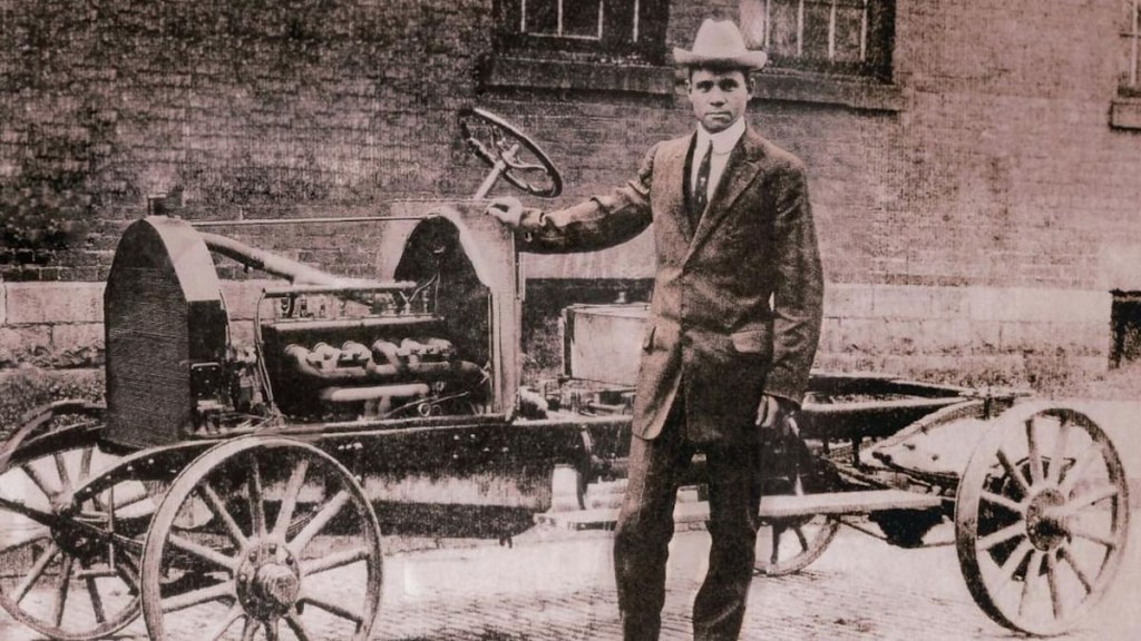 Charles Patterson standing in front of a C.R. and Sons car, the first Black-owned car company in the world