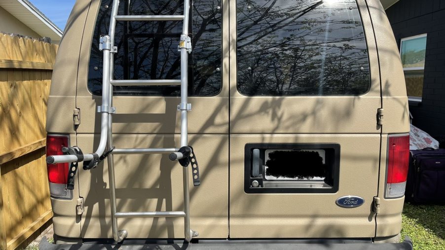 rear view of the ladder and bike rack of a tan ford e350 camper van