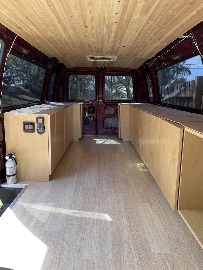 interior of the Ford E350 camper van finished out with wood cabinets and tongue in groove ceiling