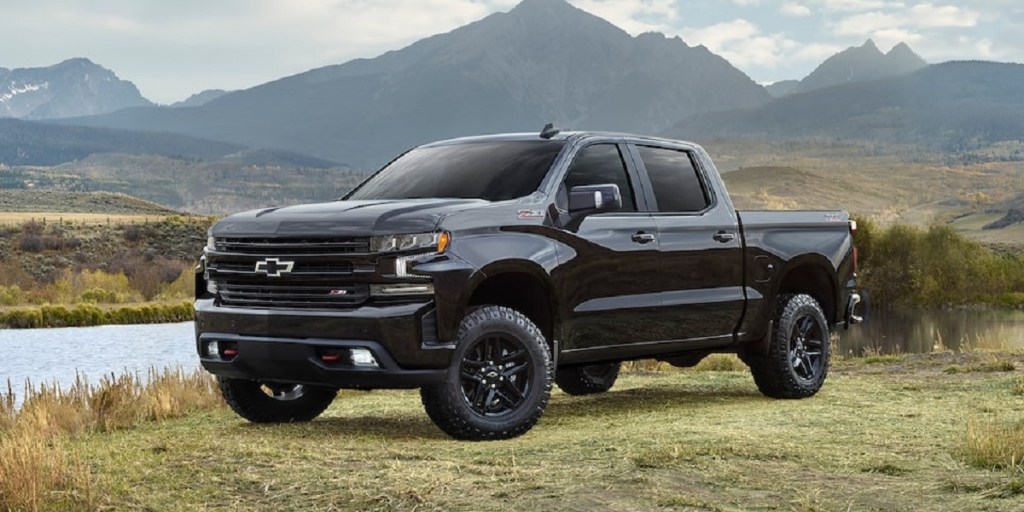 A black 2021 Chevy Silverado on a grassy bank. The Silverado is one of the pickups with the worst headlights.
