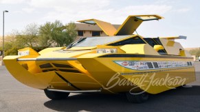 The yellow Dobbertin Hydrocar with its doors open parked in a parking lot
