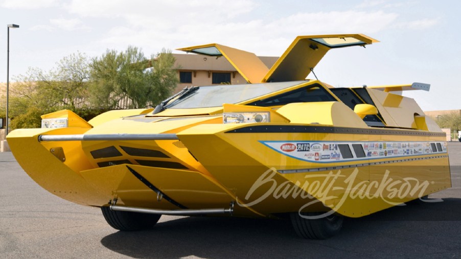 The yellow Dobbertin Hydrocar with its doors open parked in a parking lot