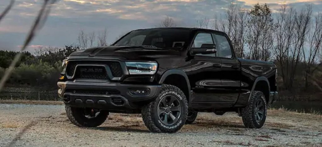 A black 2021 Dodge Ram 1500 with trees in the background.