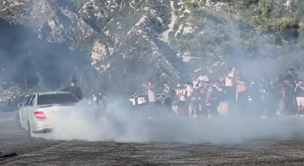 Complete idiots drifting Mercedes sedan in a crowd