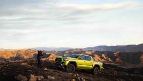 A photographer snapping the 2022 Toyota Tacoma TRD Pro on a mountain