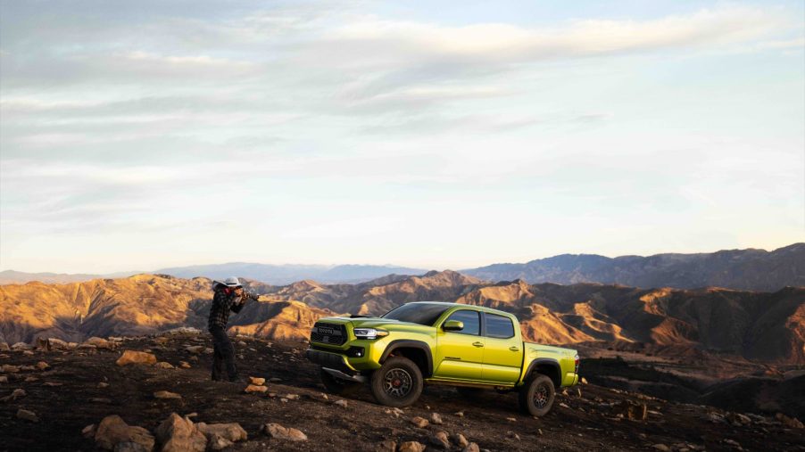 A photographer snapping the 2022 Toyota Tacoma TRD Pro on a mountain
