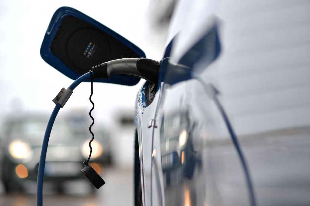 A blue EV being charged at a charging station