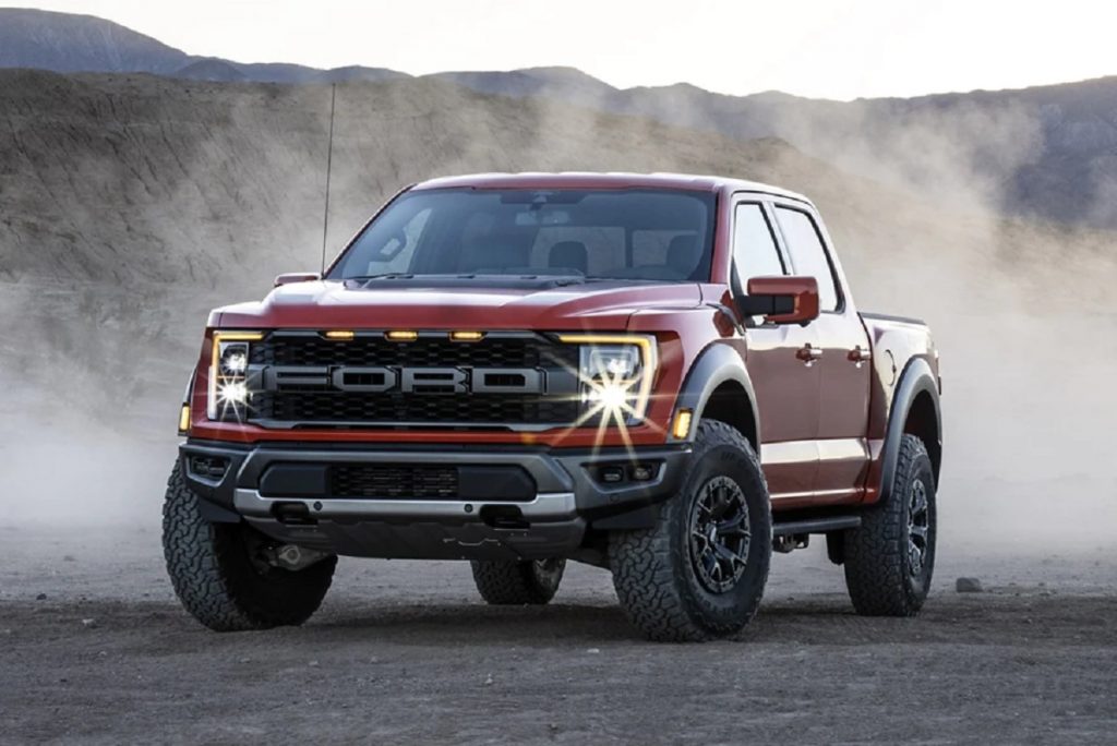 A red 2021 Ford F-150 kicks up dirt.