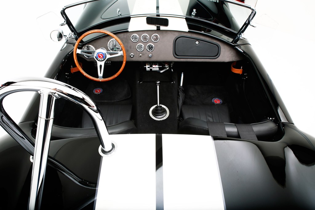 An overhead view of the black interior of a black-with-white-stripes Factory Five Racing Mk4 Roadster Shelby Cobra 427 replica kit car
