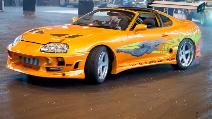 A yellow Toyota Supra coupe performing Fast and Furious Live