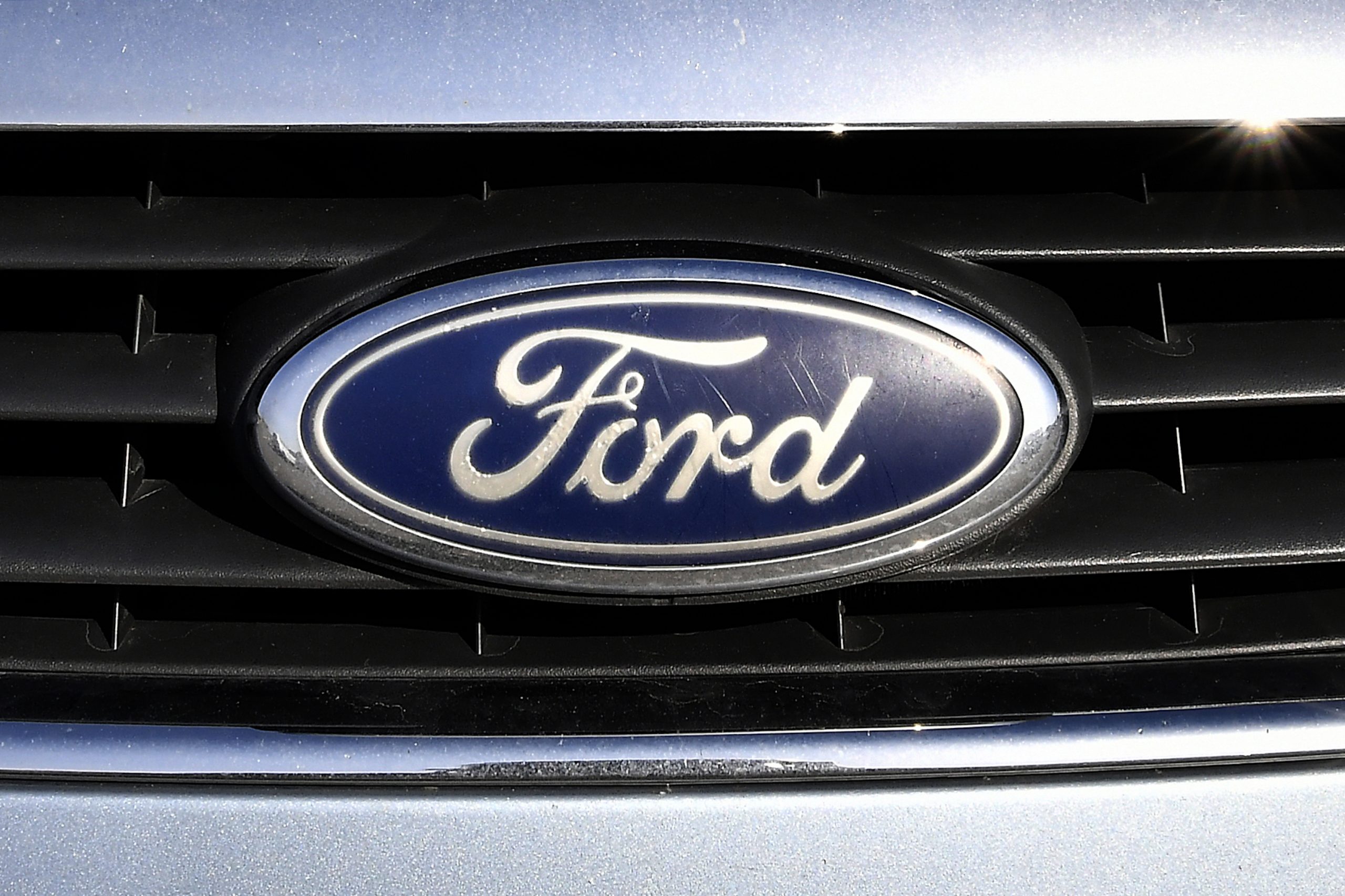 A blue oval Ford logo on a vehicle grille