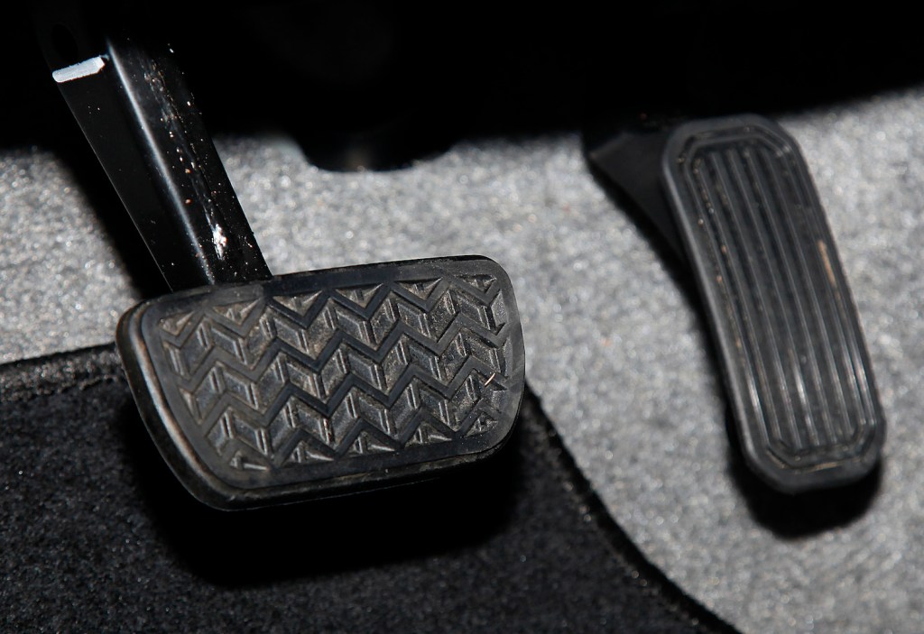 The brake and accelerator pedals of a used Toyota Prius automobile are seen at a dealership