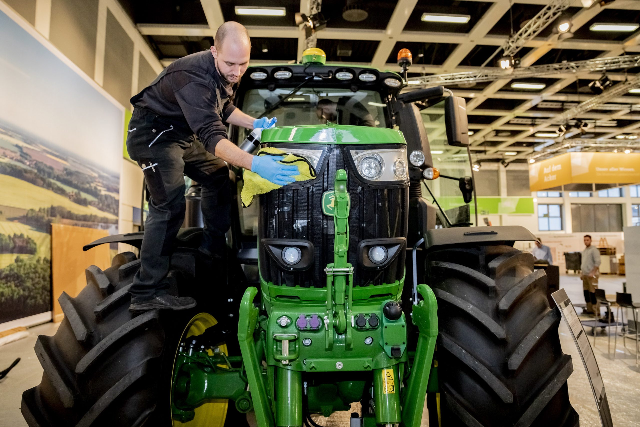 a man cleaning the front end of a new John Deere tractor
