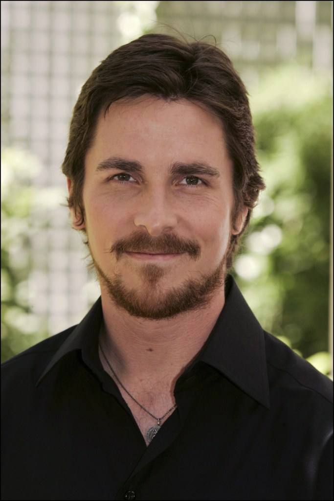 a recent head shot of actor Christian Bale gently smiling into the camera 