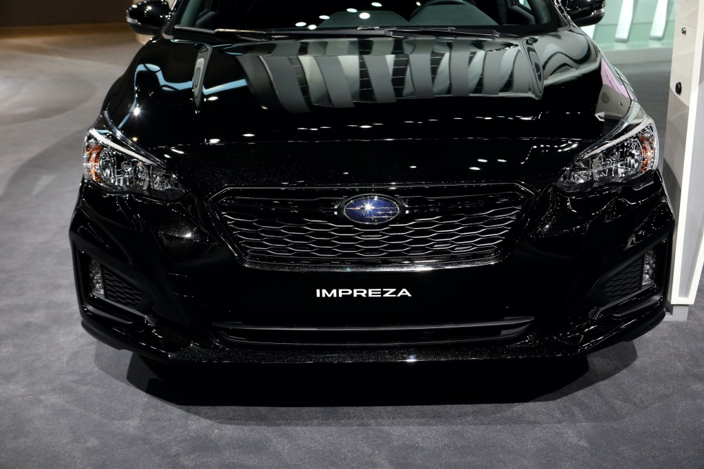 front grille view of a black Subaru Impreza on display at an auto show