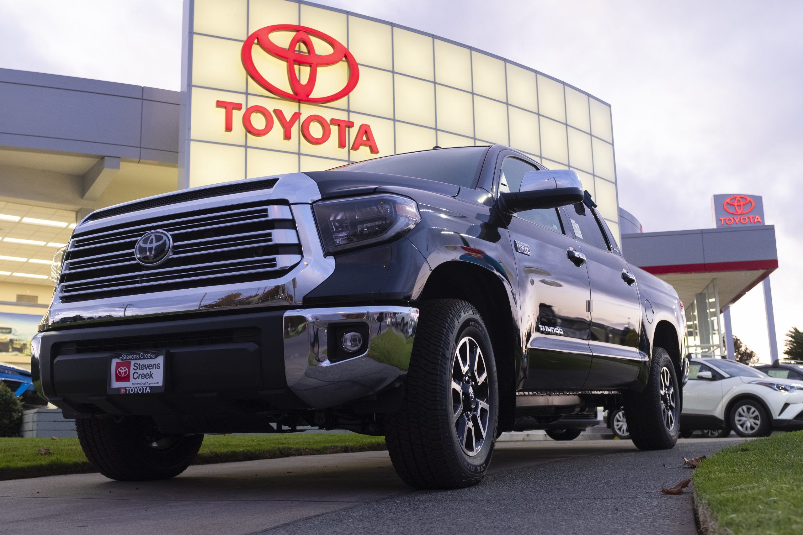 A Toyota Tundra pickup sits outside a dealership at sunset