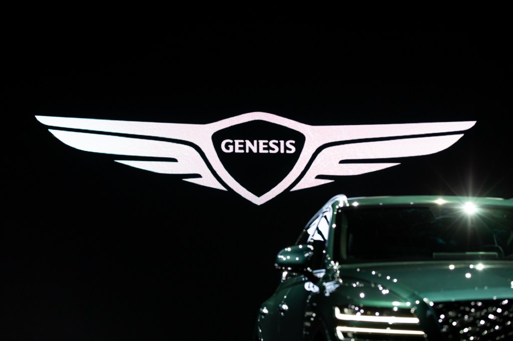 The GV80 in front of a large Genesis logo