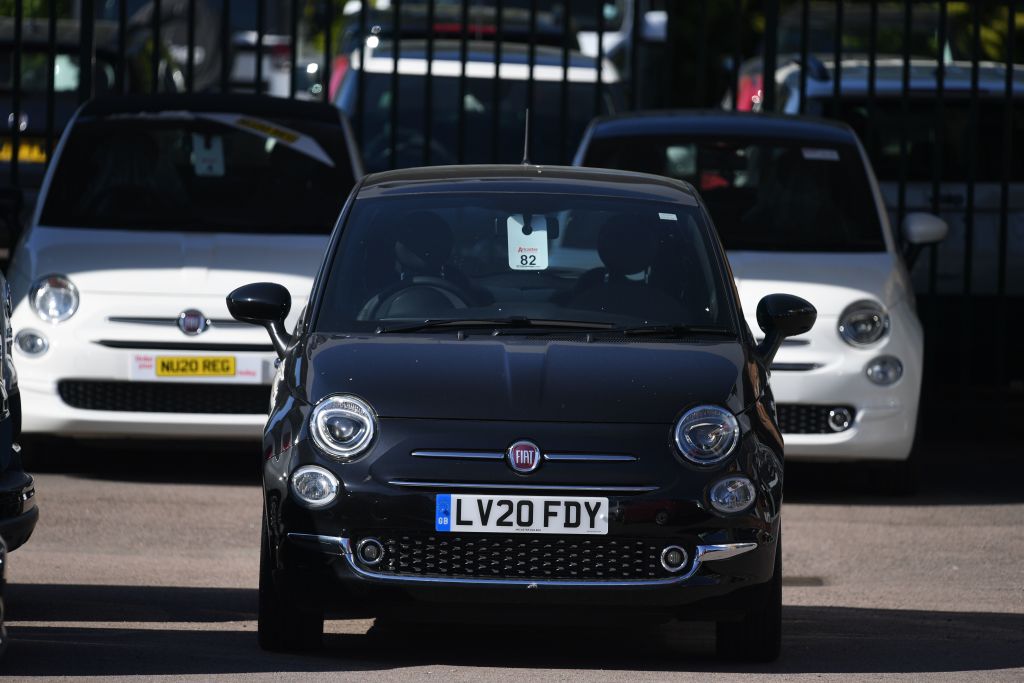 A gas-powered black Fiat 500 with other 500 models in 