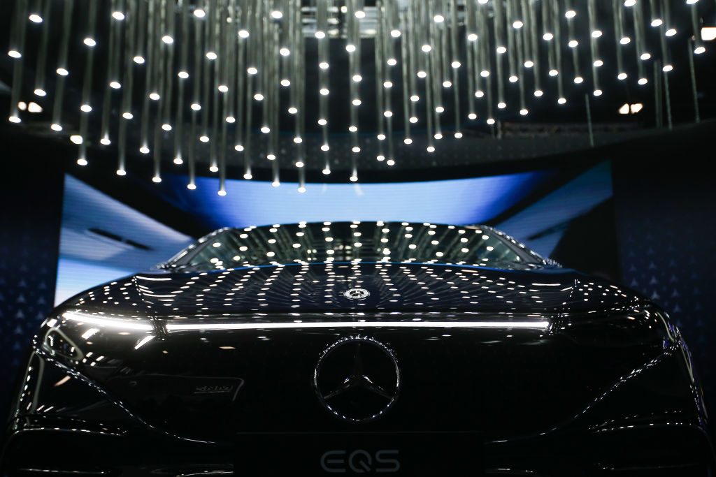 The new electric Mercedes EQS with string lights reflecting off the dark blue paint