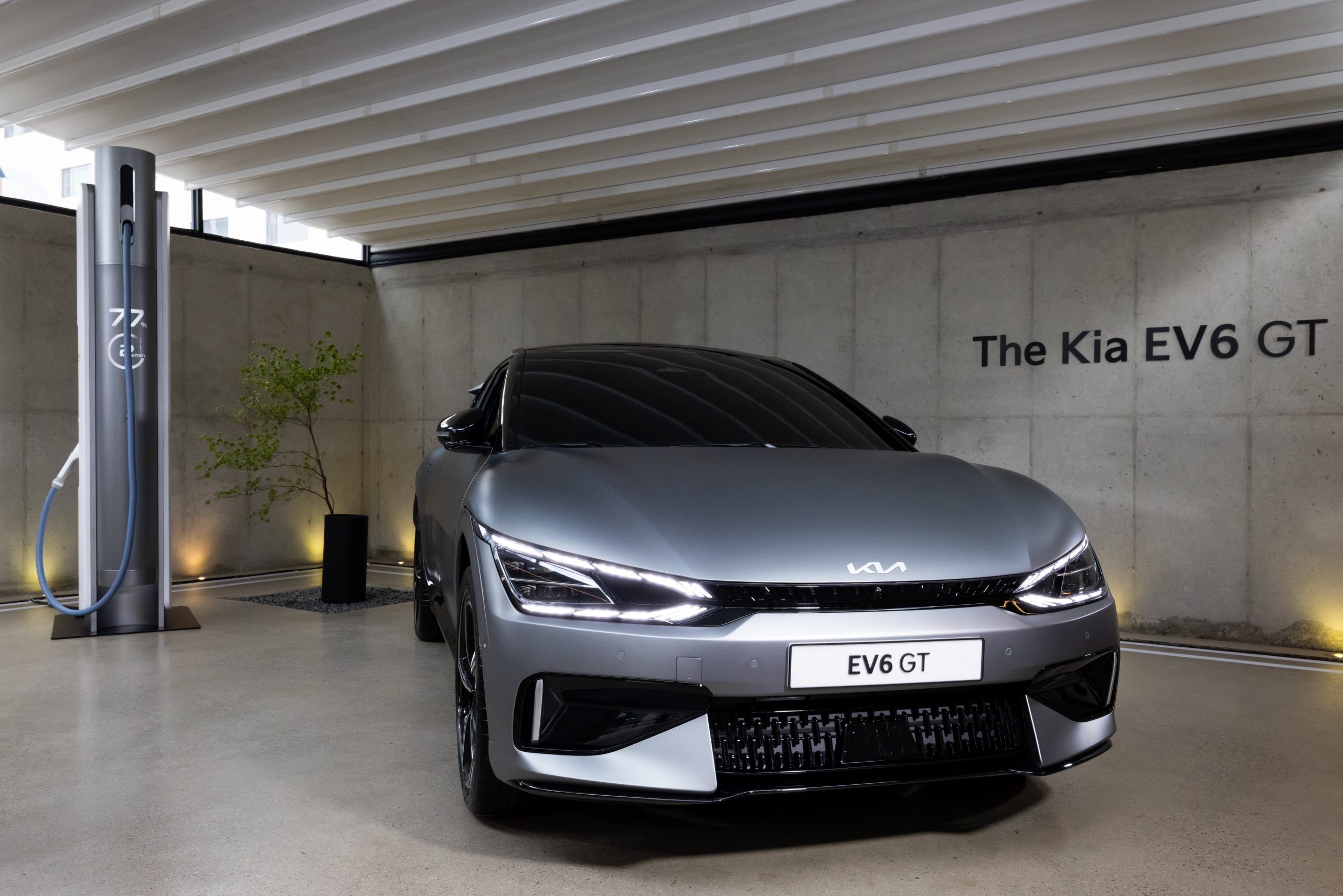 Kia's EV6 next to a charger in a garage