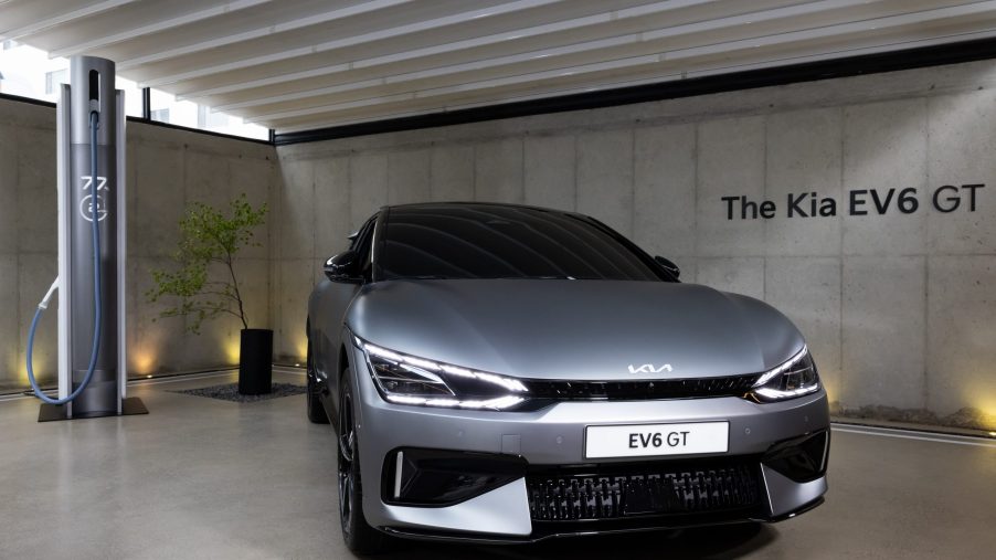 Kia's EV6 next to a charger in a garage