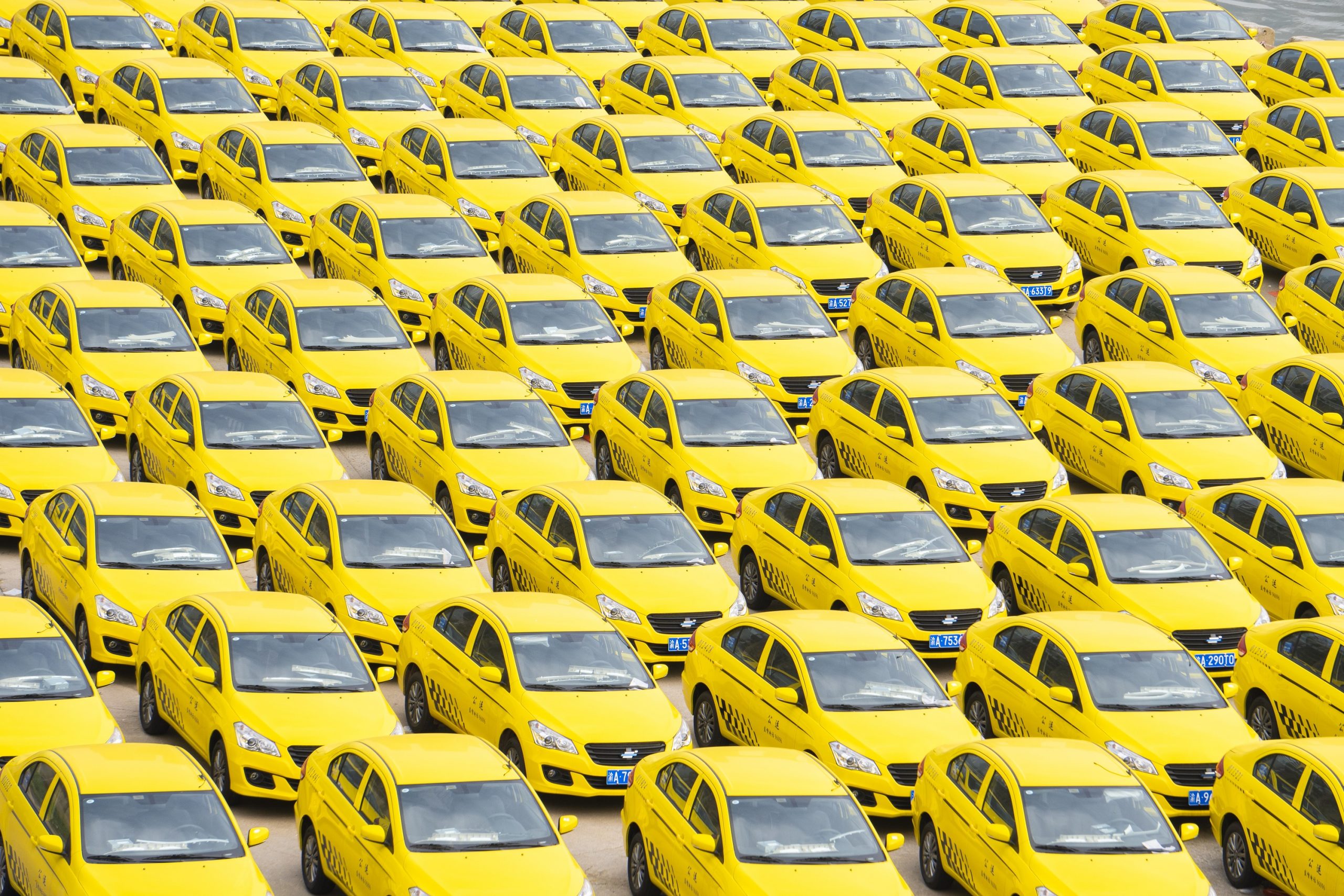 A fleet of yellow cars on a lot
