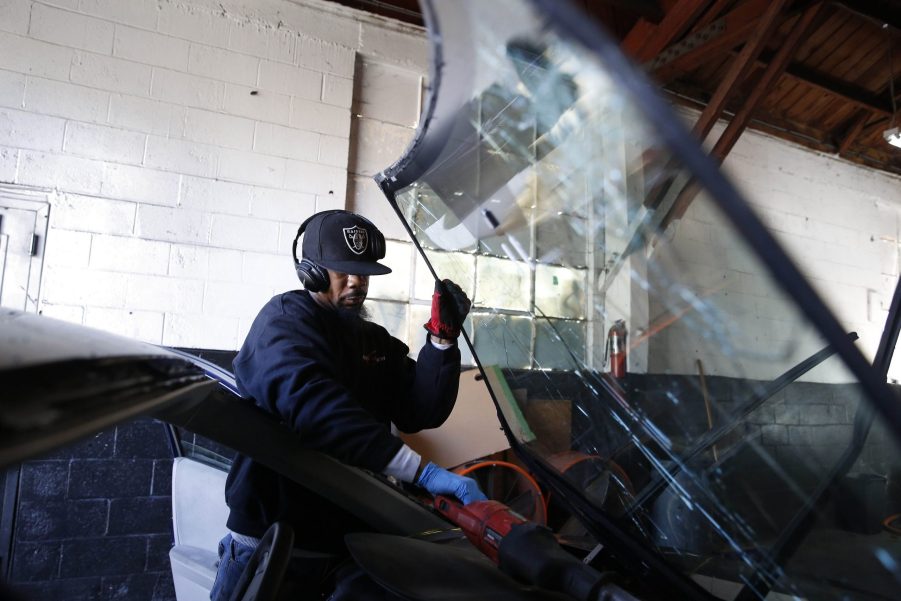 A man working on windshield repairs in a dealership