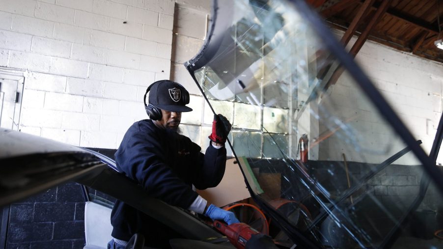 A man working on windshield repairs in a dealership